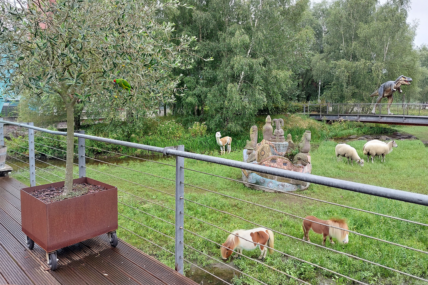 Schafe, Shetland-Ponys und ein Dinosaurier vor der Terrasse des whisky & cigar salons - eine Visualisierung.