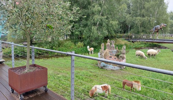 Schafe, Shetland-Ponys und ein Dinosaurier vor der Terrasse des whisky & cigar salons - eine Visualisierung.